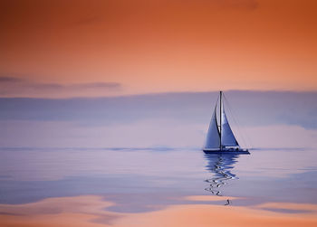 Sailboat sailing on sea against sky during sunset