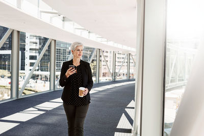 Full length of woman standing by window