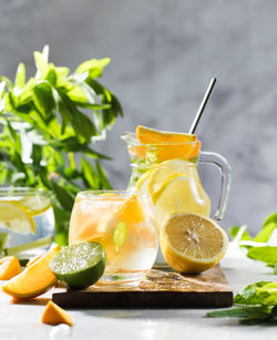 Refreshing lemonade with lemon and mint in a jug and glass on a wooden board. summer drinks. 