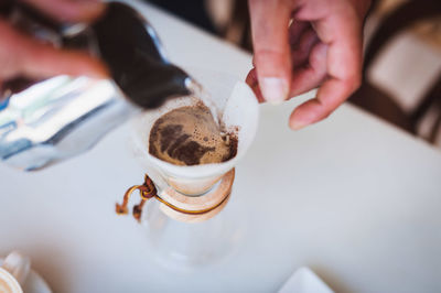 Cropped image of barista making coffee at cafe