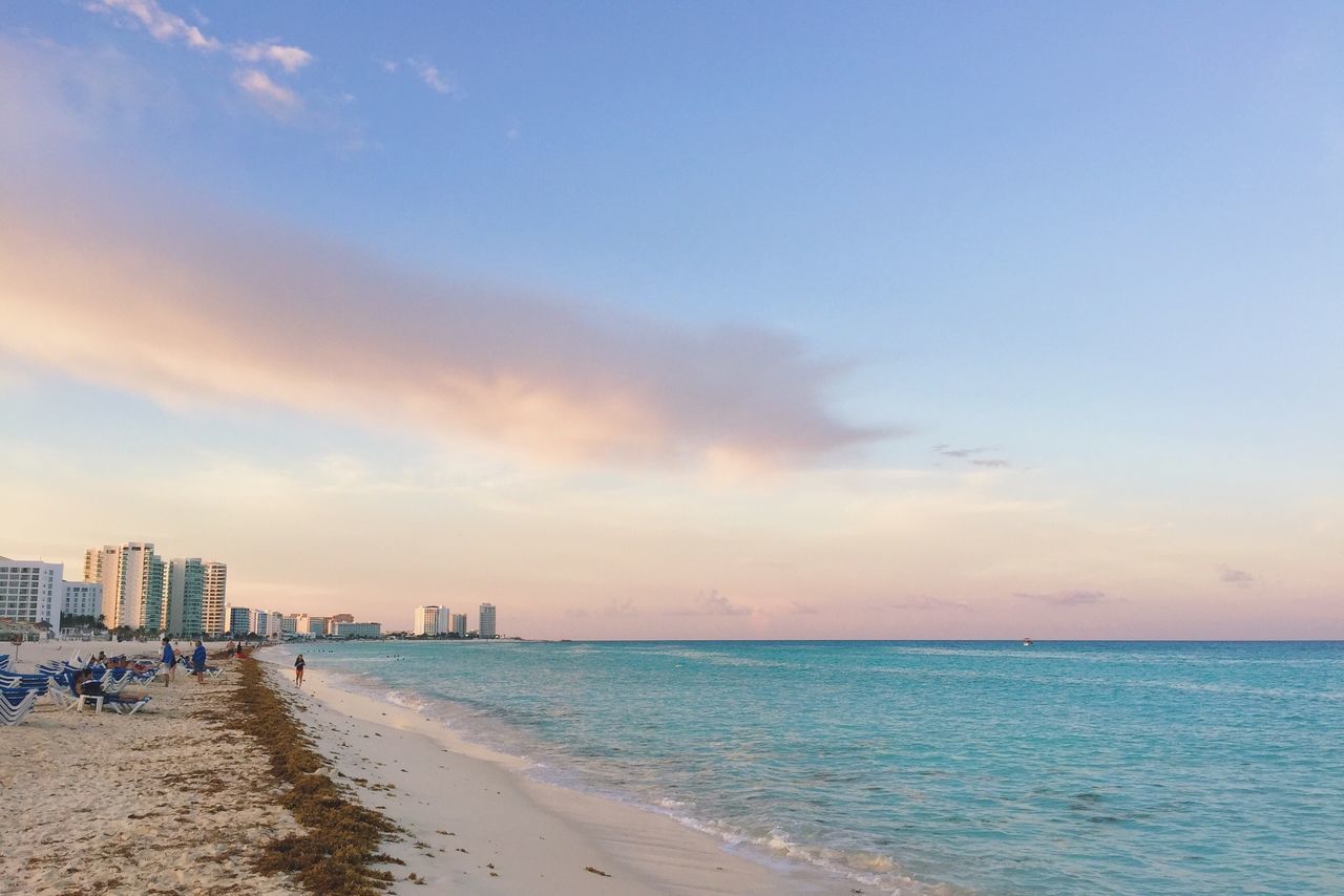 sea, beach, water, sky, horizon over water, shore, sand, built structure, scenics, architecture, tranquility, tranquil scene, beauty in nature, incidental people, building exterior, nature, cloud - sky, coastline, idyllic, vacations