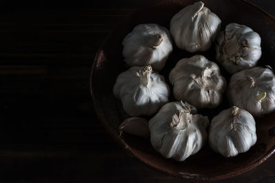 Close-up of garlic bulbs in plate on table