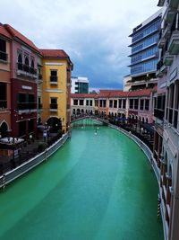 Canal by buildings in city