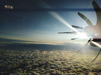 Airplane flying over landscape against sky