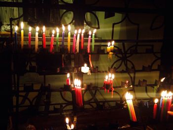 Close-up of lit candles in row at night