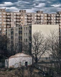 Buildings in city against cloudy sky