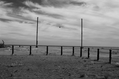 Pier on sea against cloudy sky