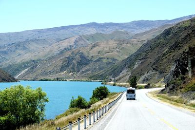 Road by mountains against sky