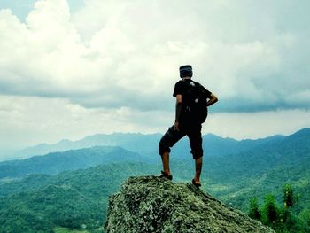 Full length of man skateboarding on mountain against sky