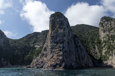 Rock formations by sea against sky