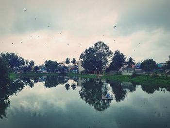 Scenic view of lake by trees against sky