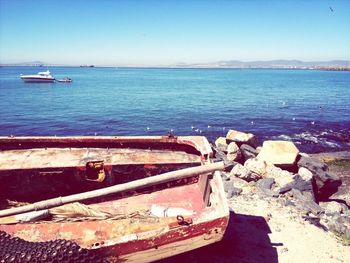 Boats in sea against clear blue sky