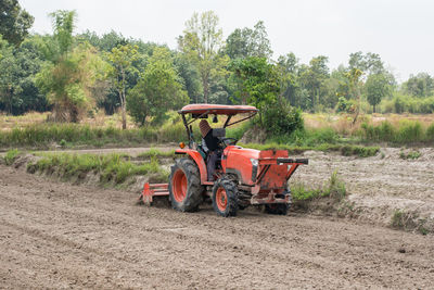 Farmer driving tractor on agricultural field