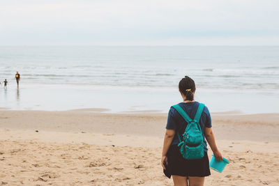 Rear view of woman standing on beach