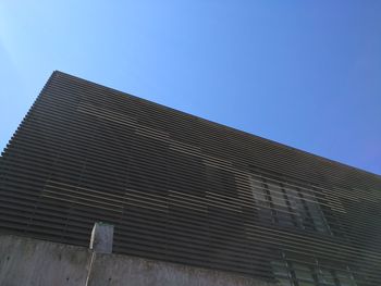 Low angle view of modern building against clear blue sky