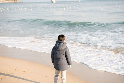 Rear view of a man walking on beach