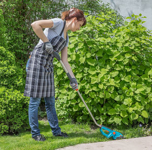 Woman standing by plants in yard