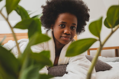 Portrait of young woman against plants