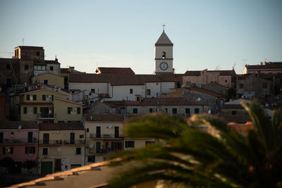 Buildings in town against clear sky