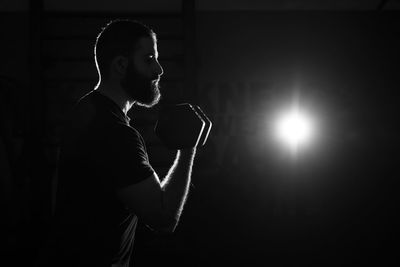 Side view of young man looking at camera