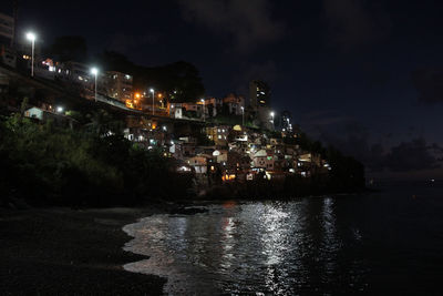 Illuminated city against sky at night