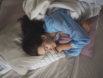 High angle view of woman lying on bed