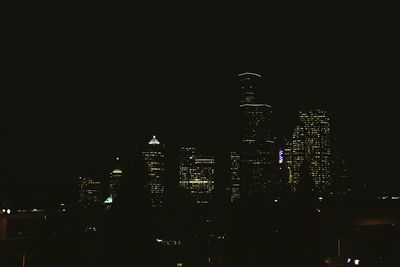 Illuminated cityscape against sky at night