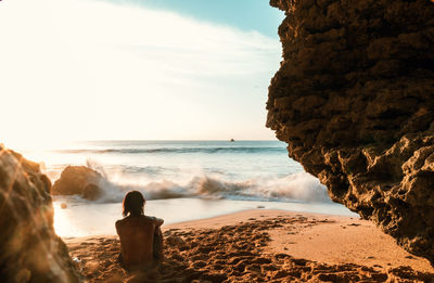 Rock formations on beach against sky