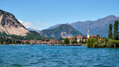 Scenic view of sea and buildings against blue sky