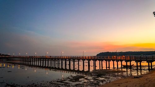 Pier over sea against sky during sunset