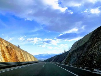 Road by mountain against sky