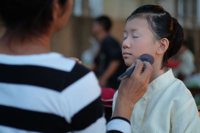 Artist make up artist applying make-up with brush on girl