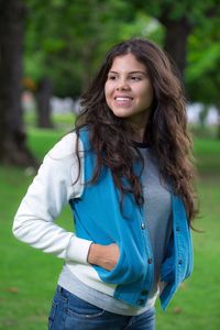 Young woman smiling while standing at park
