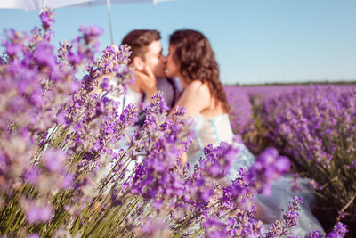 Woman with pink flowers on field against sky