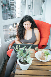 Portrait of young woman sitting on sofa at home