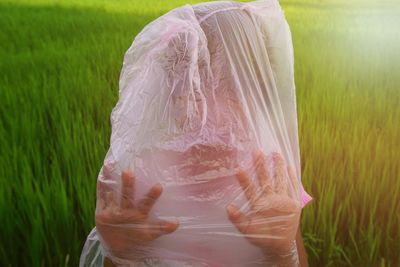 Midsection of woman with umbrella on field