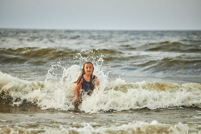 Side view of shirtless man surfing in sea