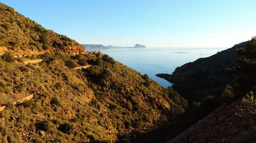 Scenic view of sea and mountains against sky