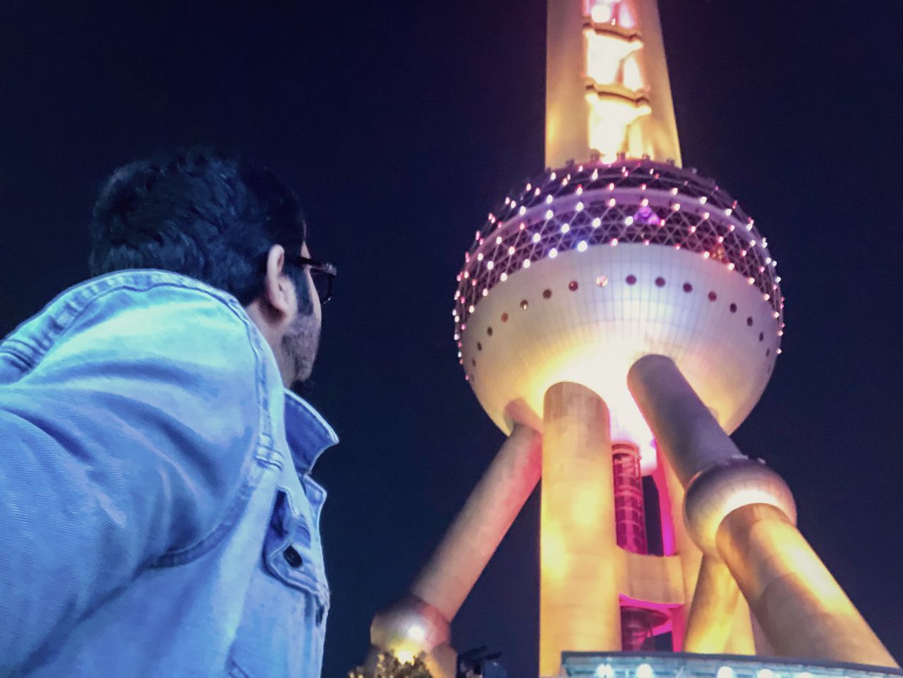 LOW ANGLE VIEW OF MAN HOLDING ILLUMINATED LIGHTING EQUIPMENT