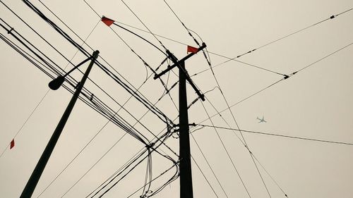 Low angle view of power lines against sky