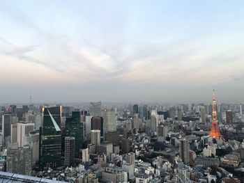 View of cityscape against cloudy sky