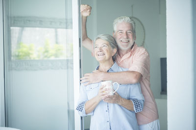 Smiling senior couple embracing at home