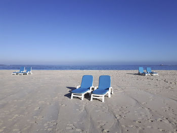 Scenic view of beach against clear blue sky