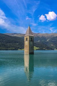 Building by lake against sky