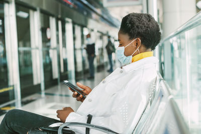 Side view of young woman using mobile phone