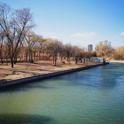 View of swimming pool by canal against sky