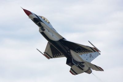 Low angle view of fighter plane flying against sky