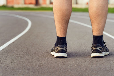 Low section of man standing on road