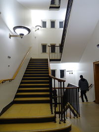 Rear view of man standing on staircase in building