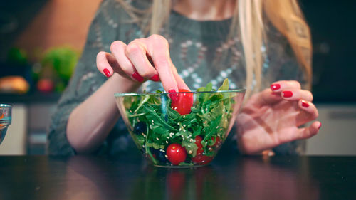 Midsection of woman holding wineglass